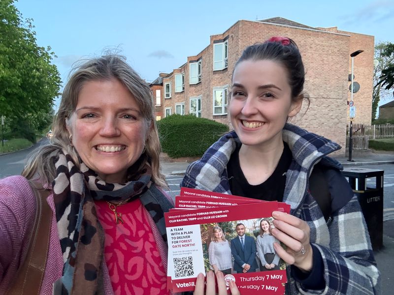 Rachel and Liz out campaigning for the May local election, smiling and holding leaflets